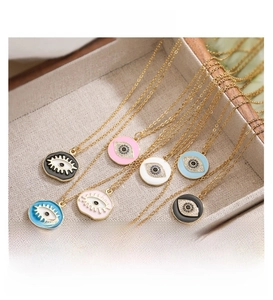 Detailed view of colorful evil eye pendants with gold eyelashes and cubic zirconia