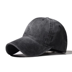 Detailed close-up of dark grey washed cotton baseball cap with retro distressed texture