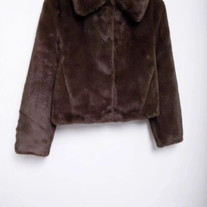 Deep brown faux fur jacket with wide lapels and short cropped fit for a chic winter look