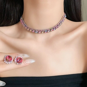 Detail view of vintage luxury necklace and earrings set with gradient pink gems on model