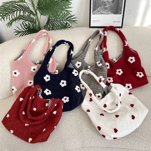 Detailed arrangement of floral embroidery plush tote bags on a stylish white sofa