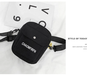 Detail of black canvas shoulder bag featuring metal magnetic buckle and logo printing