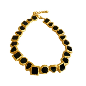 Vintage geometric gold necklace with black gemstone inlay on a clean white background