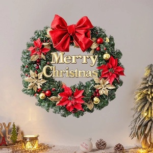 Christmas wreath with red velvet bow and golden Merry Christmas sign on wall