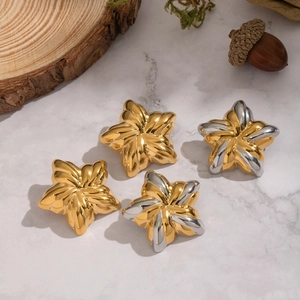 Boucles d'oreilles étoile de mer bicolores en or 18 carats et argent sur marbre