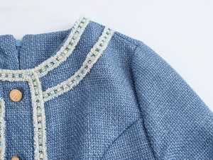 Detailansicht der blauen Tweed-Kleid mit goldenen Borten und dekorativen Goldknöpfen