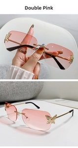 Close-up of frameless pink gradient sunglasses with golden butterfly metal ornaments