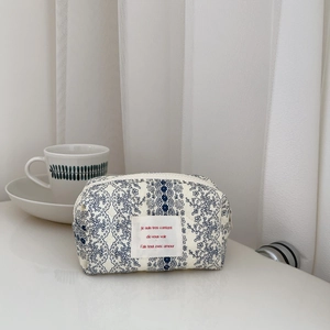 Detail of floral quilted cotton bag with French script label and dainty blue flowers