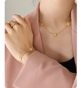 Close-up of gold star necklace and bracelet set with zircon stones worn by a model