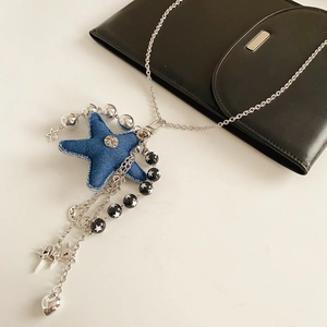 Detail of denim starfish pendant necklace with silver chain and star charm accents