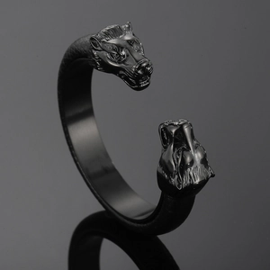 Detail shot of double wolf heads on a black punk style open cuff bracelet with reflection
