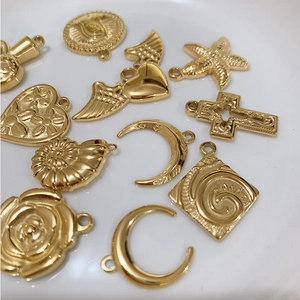Assorted gold titanium steel pendants featuring moon, starfish, heart and cross shapes