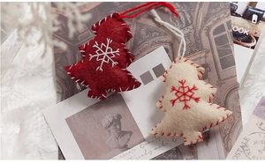 Detailed view of handmade wool felt Christmas tree ornaments with stitched snowflakes
