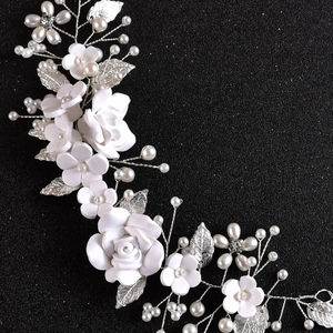 Detail of handmade bridal headband with white clay flowers, silver leaves and pearls