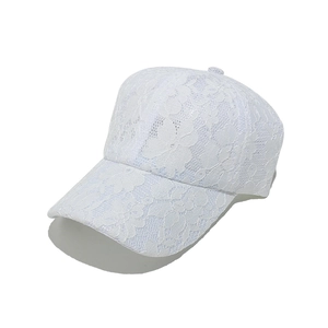 Dettaglio della trama in pizzo floreale bianco e mesh del cappello da baseball