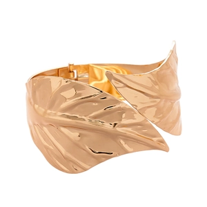Golden wide leaf cuff bracelet with intricate vein texture on a white background