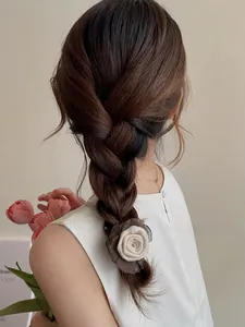 Detail of bicolored rose hair tie in coffee and cream on a braided hairstyle