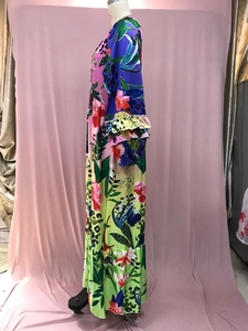 Detalle de vestido largo estampado con escote en V, mangas con volantes y diseño tropical