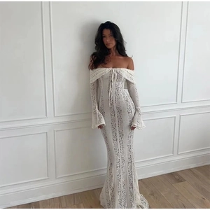 Close-up of off-the-shoulder lace dress featuring intricate floral patterns and tie-up detail