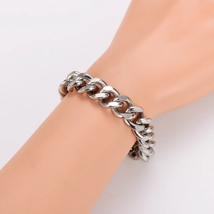 Men's thick silver stainless steel Cuban link chain bracelet on a male wrist