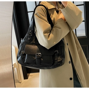 Detailed view of a black large-capacity PU leather tote bag with flap pockets and buckles