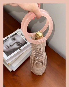 Detailed shot of pink beaded wine bag with large ring handles for luxury gifting