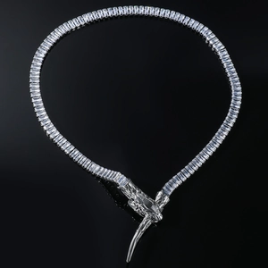 Detailed macro view of silver snake necklace with rectangle zircons on black surface