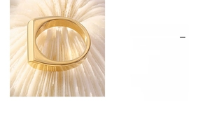 Macro shot of minimalist gold plated stainless steel ring with flat rectangular surface