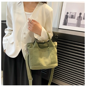 Detail of green canvas tote bag with adjustable shoulder strap and external pocket