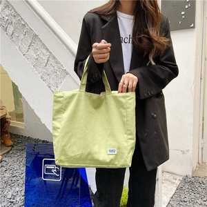 Bolso tote minimalista de lona verde claro con etiqueta tejida para uso diario casual