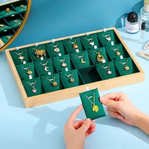 Bamboo wood 24-slot jewelry display tray with green velvet lining and gold necklaces
