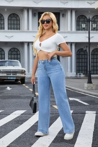 Photo en extérieur d'un crop top blanc avec un jean taille haute bleu clair à jambes larges