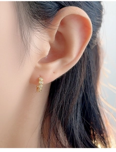 Macro shot of gold hoop earrings featuring micro-paved round cubic zirconia stones