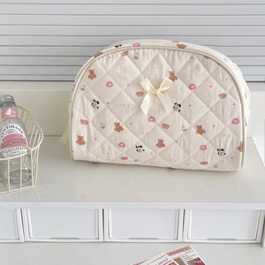 Detailed view of the quilted fabric texture with cute bear patterns and a yellow bow