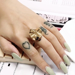 Detailansicht eines goldenen gewellten Rings am Finger vor neutralem Hintergrund