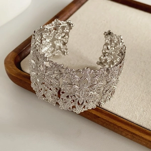 Close-up of vintage hollowed pattern wide cuff bracelet with silver metal texture