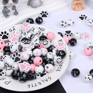 Detail of wooden pet beads with paw and bone prints on a decorative white plate