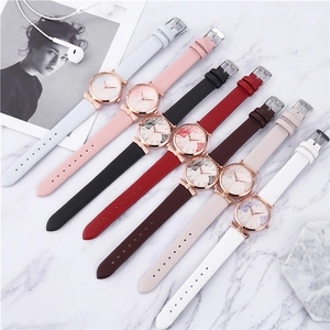 Detailed flat lay of ladies' watches with leaf prints and colorful leather straps