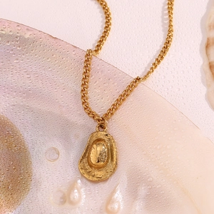 Detail view of gold 18K plated cowboy hat pendant necklace on water droplet background
