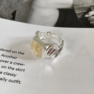 Detail of S925 silver ring with irregular liquid metal texture and square yellow stone