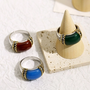Macro detail of retro steel rings with rectangular gemstones in red, blue and green