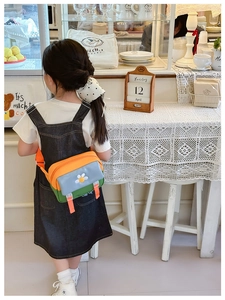 Kids crossbody bag with daisy patch and color-block design in a cafe setting