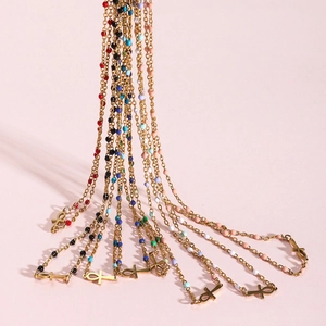 Gold plated stainless steel Ankh cross necklaces with colorful beads on pink background