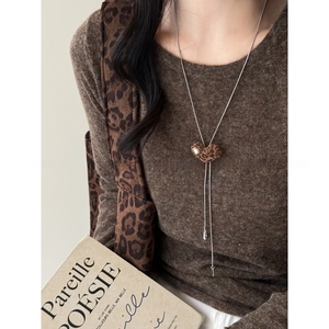 Vintage leopard heart pendant necklace on silver chain worn with a brown knit sweater