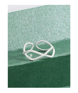 Detailed macro shot of an S925 sterling silver twisted rope ring on a green luxury box