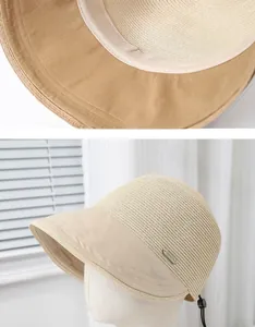 Detail of straw equestrian sun hat showing fabric brim and fashion metal label