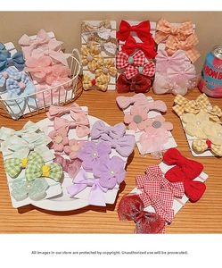 Collection of colorful bow and flower elastic hair ties on white display cards