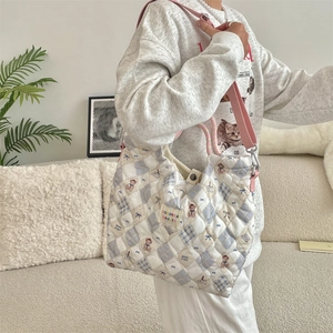 Detailed quilted fabric texture with cute bear patterns on a soft cotton shoulder bag