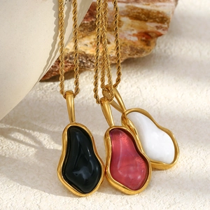 Detailed macro of 18K gold plated twisted chains with resin geometric pendants