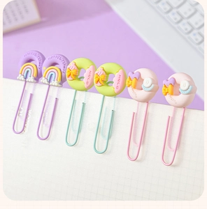 Macro view of cute macaron paperclips with rainbow, donut, and bow resin decorations